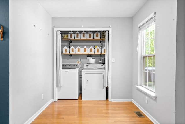 laundry room with light hardwood / wood-style flooring and independent washer and dryer