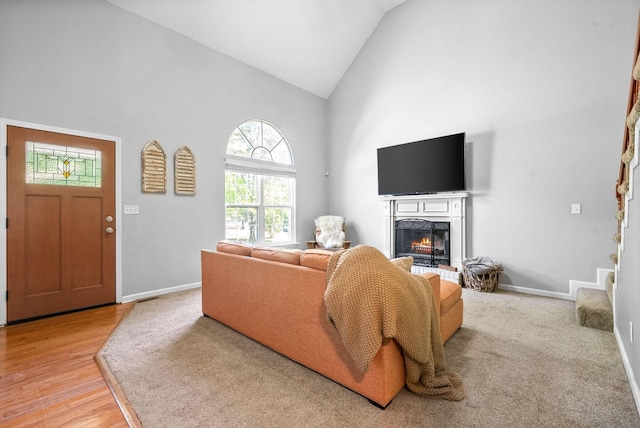 living room featuring light hardwood / wood-style flooring and high vaulted ceiling