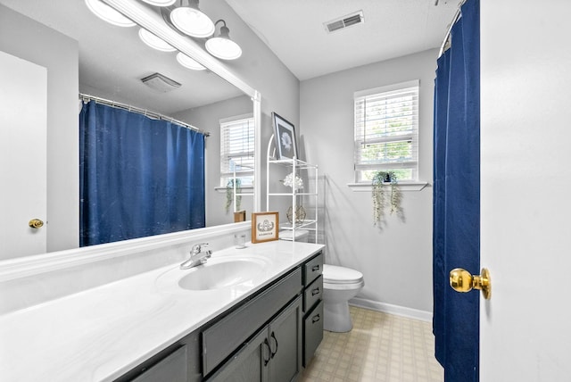 bathroom featuring toilet, vanity, and a wealth of natural light