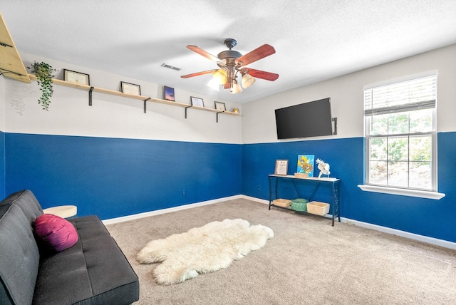 recreation room featuring ceiling fan, a textured ceiling, and carpet flooring