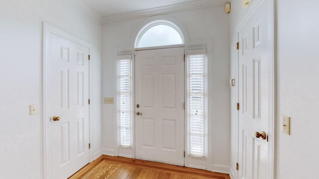 foyer featuring crown molding and light hardwood / wood-style flooring