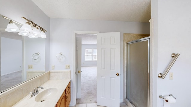 bathroom featuring a shower with shower door, vanity, tile patterned flooring, and a textured ceiling