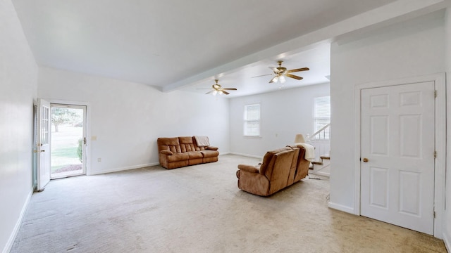 sitting room with ceiling fan, light colored carpet, and beamed ceiling