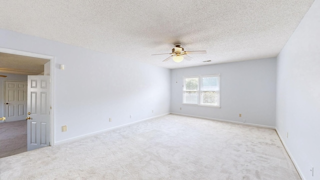 carpeted empty room featuring ceiling fan and a textured ceiling