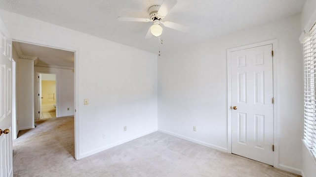 unfurnished bedroom featuring ceiling fan and light carpet