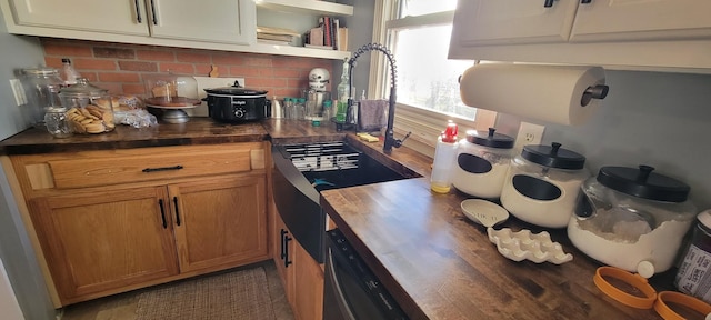 kitchen featuring backsplash, dishwasher, and wood counters