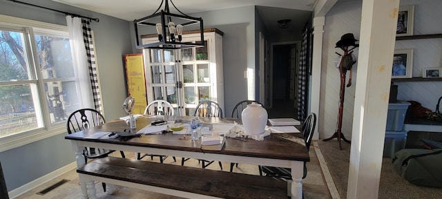 dining area featuring a wealth of natural light and an inviting chandelier