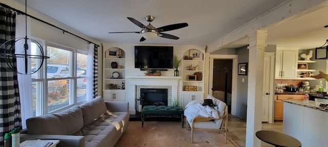 living room featuring ceiling fan and built in shelves