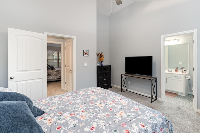 bedroom featuring ceiling fan, light colored carpet, ensuite bath, and lofted ceiling