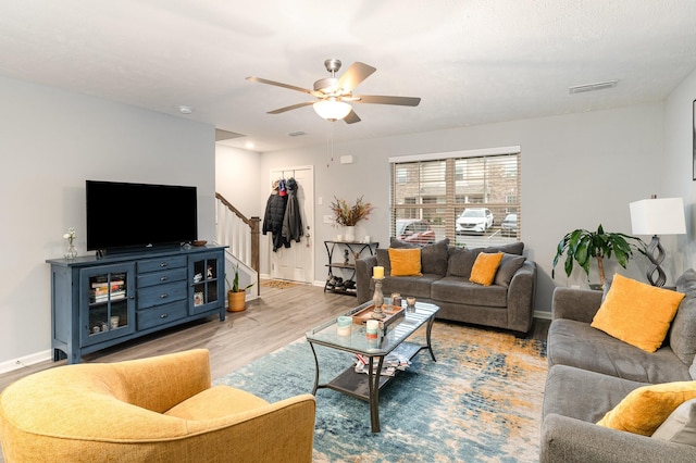 living room featuring ceiling fan and light hardwood / wood-style flooring