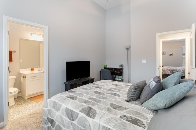 bedroom featuring light colored carpet and ensuite bath