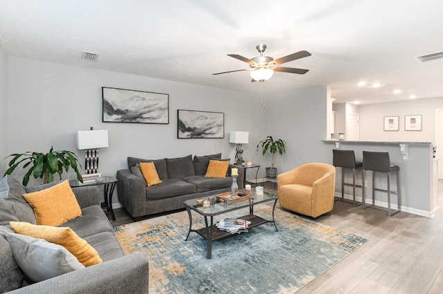 living room featuring ceiling fan and light hardwood / wood-style floors