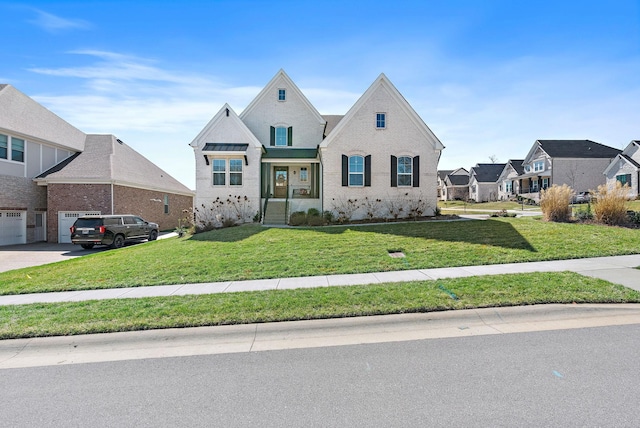 view of front of home with a garage, driveway, a front lawn, and brick siding