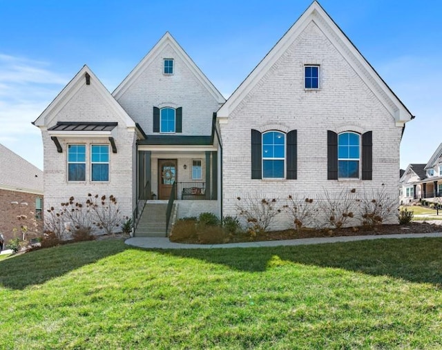 french country home with a front lawn and brick siding