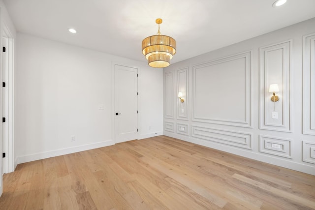 unfurnished room featuring light hardwood / wood-style floors and a notable chandelier