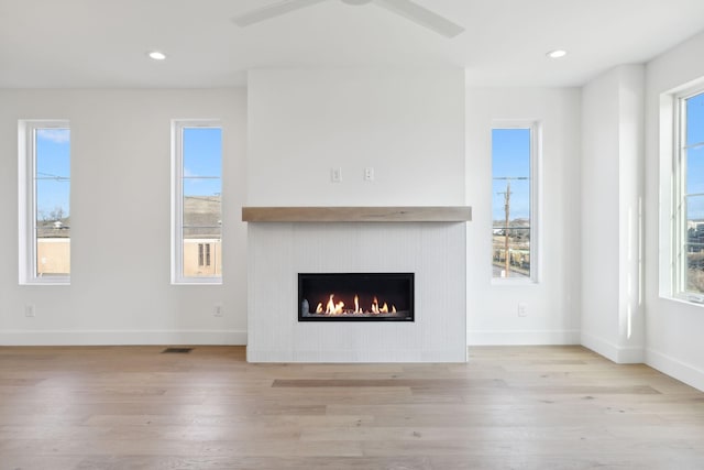 unfurnished living room featuring ceiling fan, a healthy amount of sunlight, and light hardwood / wood-style floors