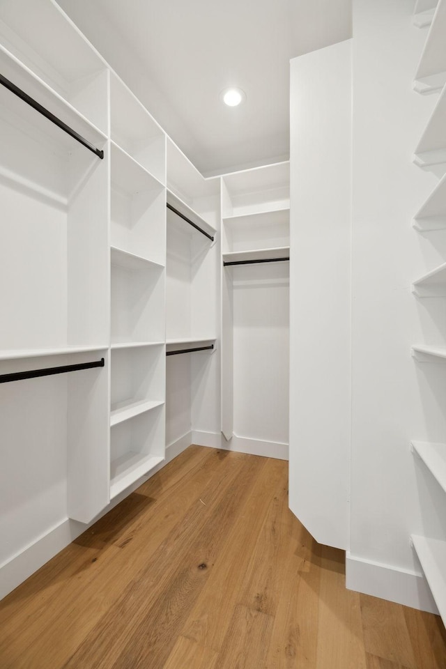 walk in closet with light hardwood / wood-style floors