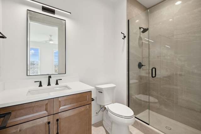 bathroom featuring vanity, toilet, ceiling fan, and a shower with door