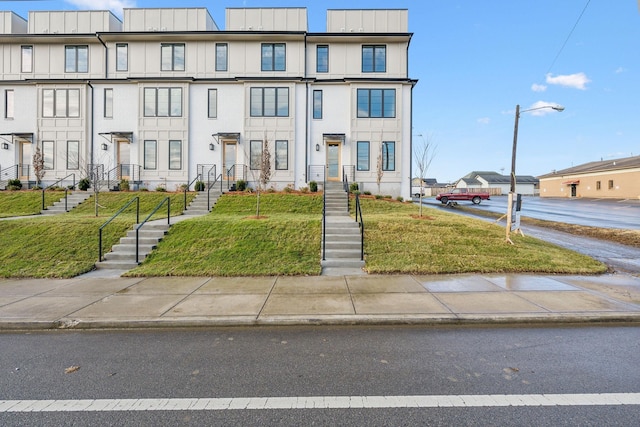 townhome / multi-family property featuring a front lawn