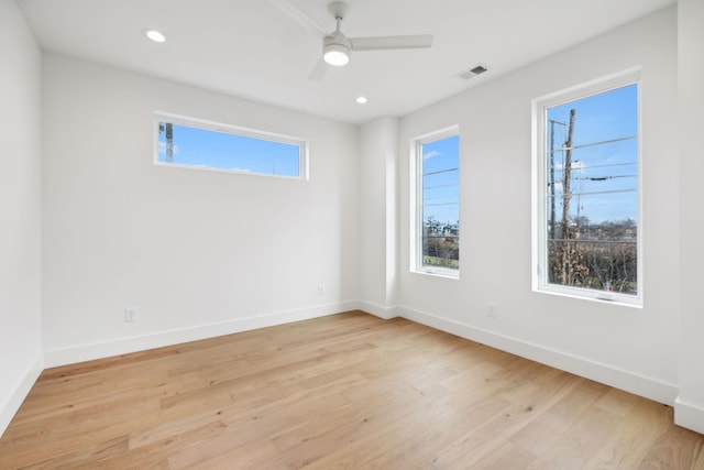 empty room with light wood-type flooring, ceiling fan, and a healthy amount of sunlight