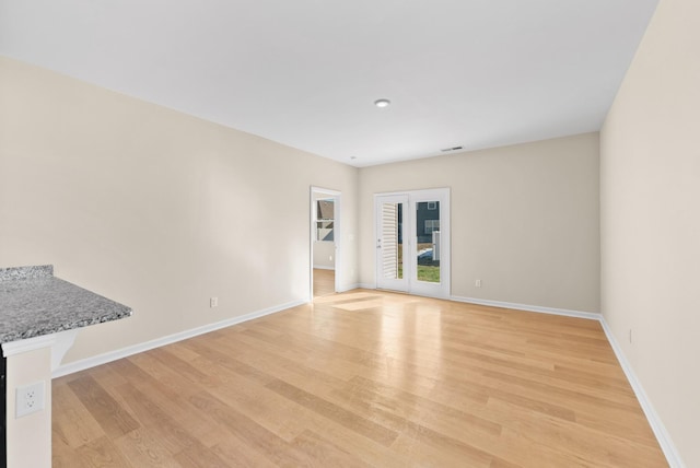 empty room with light hardwood / wood-style flooring