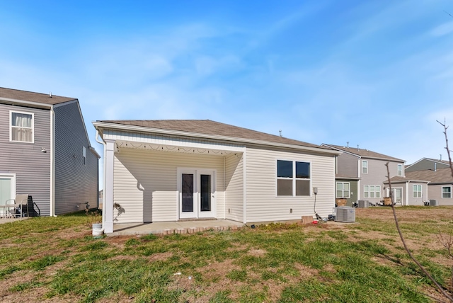 rear view of house with a yard and central AC