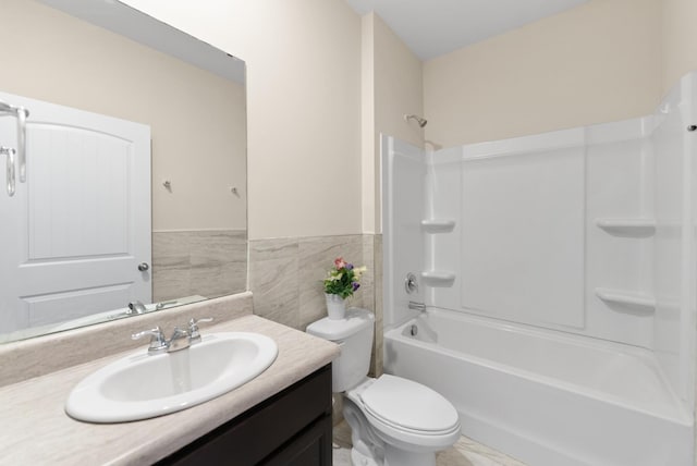 full bathroom with tile walls, toilet, vanity, and bathing tub / shower combination