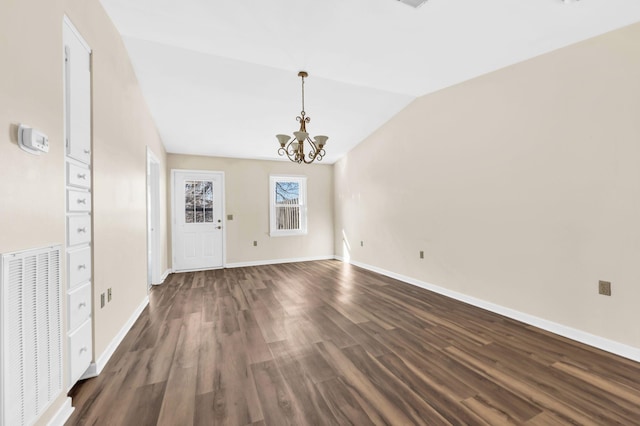 interior space with vaulted ceiling, an inviting chandelier, and dark wood-type flooring