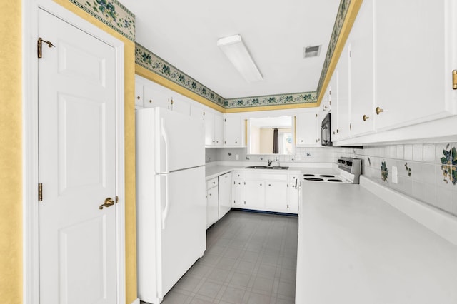 kitchen featuring sink, backsplash, white cabinetry, and white appliances