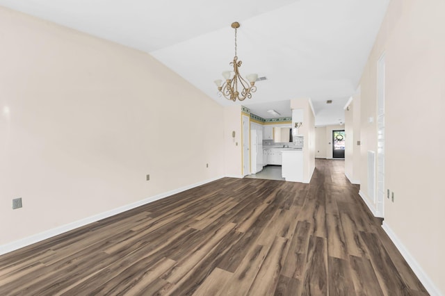 unfurnished living room with dark wood-type flooring, vaulted ceiling, and an inviting chandelier