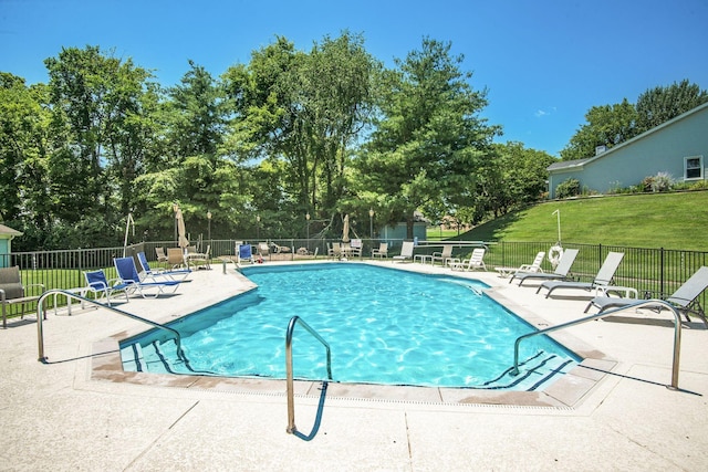 view of swimming pool with a patio area and a lawn