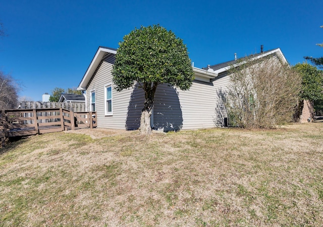 view of home's exterior with a wooden deck and a lawn