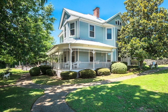 view of front of house with covered porch and a front lawn