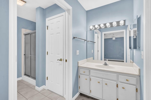 bathroom featuring tile patterned flooring, an enclosed shower, and vanity