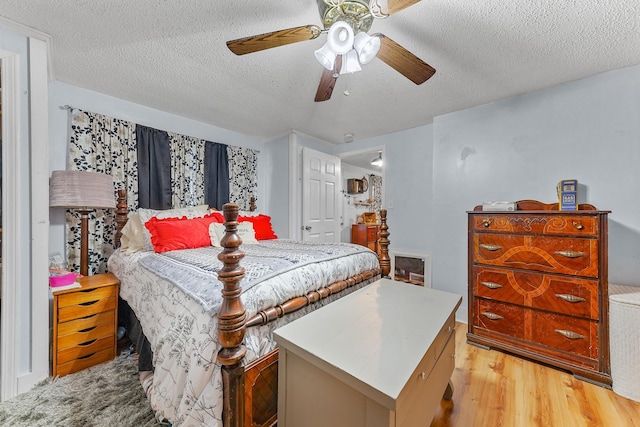 bedroom featuring a textured ceiling, ceiling fan, and light hardwood / wood-style flooring