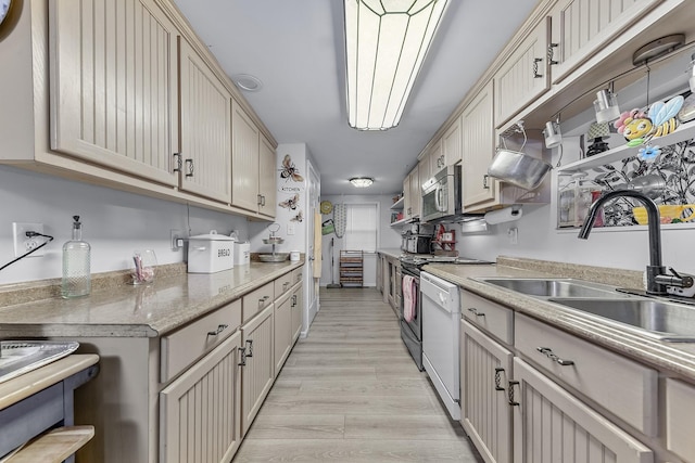 kitchen featuring light stone counters, sink, white dishwasher, and light hardwood / wood-style floors