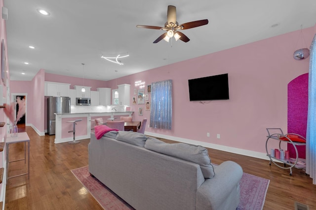 living room with ceiling fan and wood-type flooring