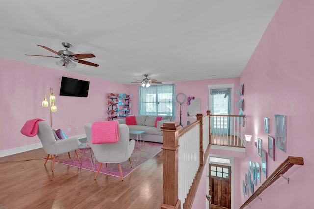 living room with ceiling fan and light hardwood / wood-style flooring