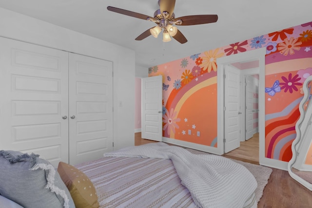 bedroom with ceiling fan, a closet, and light hardwood / wood-style floors