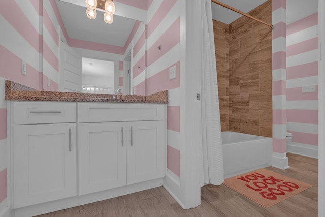 bathroom featuring hardwood / wood-style flooring, vanity, and shower / tub combo with curtain