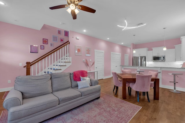 living room with ceiling fan and light hardwood / wood-style floors