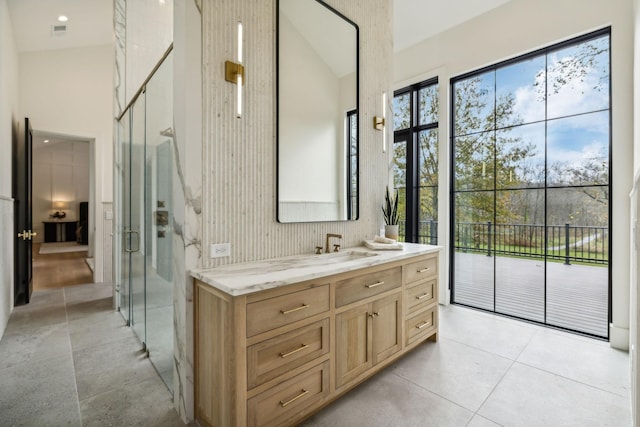 bathroom with tile patterned flooring, vanity, vaulted ceiling, and a shower with door