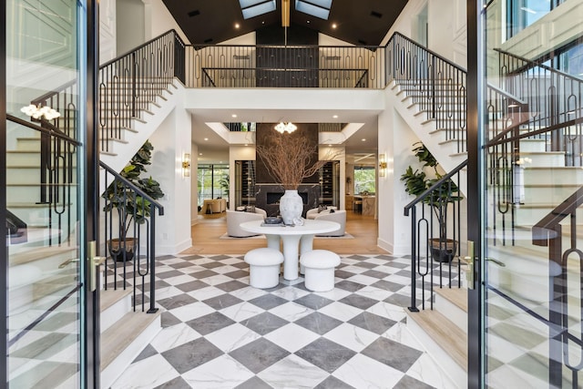 entryway with high vaulted ceiling, an outdoor fireplace, a wealth of natural light, and beamed ceiling