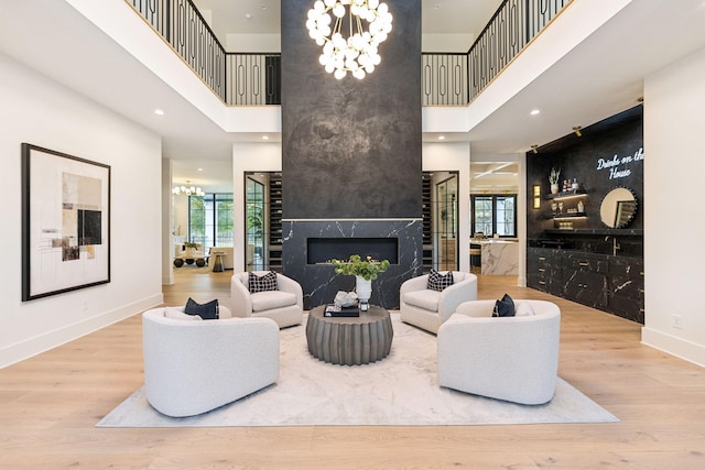 living room with hardwood / wood-style flooring, a high ceiling, and a high end fireplace