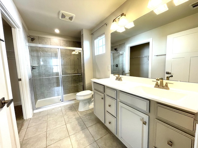 bathroom featuring a shower with door, tile patterned floors, vanity, and toilet