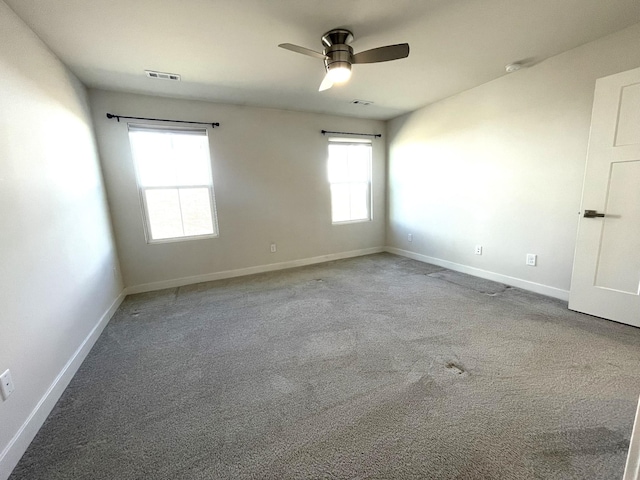 carpeted spare room featuring ceiling fan