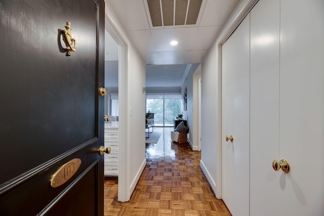 corridor featuring a paneled ceiling and dark parquet floors