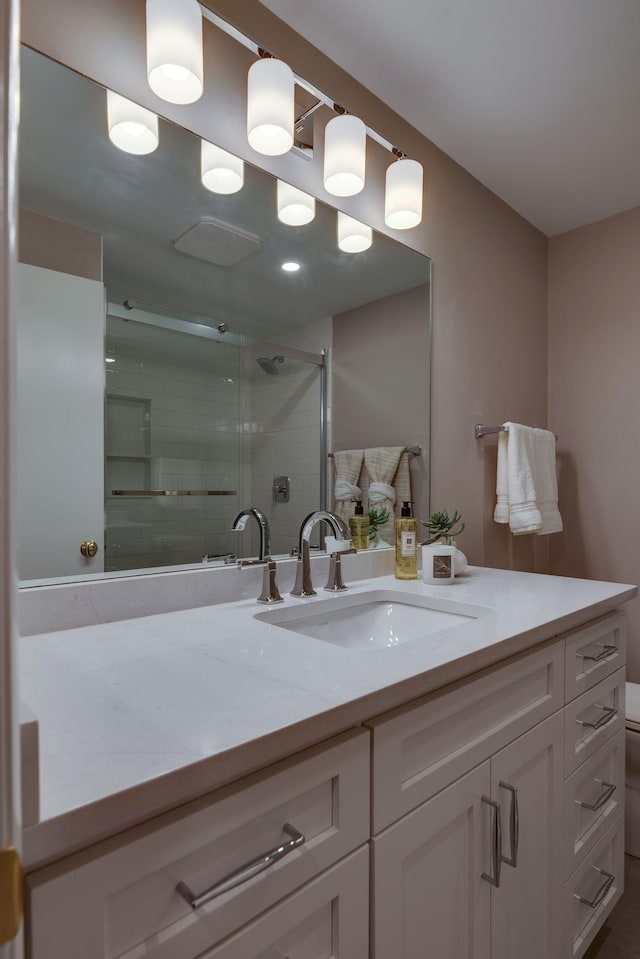 bathroom featuring an enclosed shower, vanity, and toilet