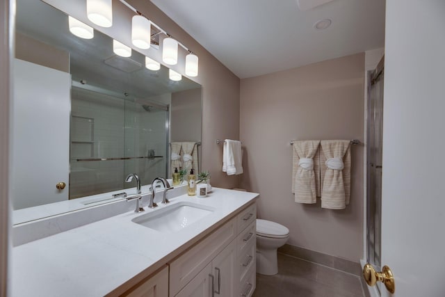 bathroom featuring toilet, tile patterned flooring, a shower with door, and vanity