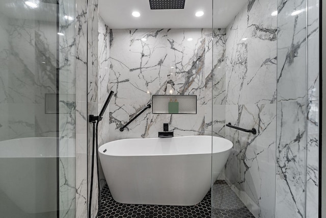 bathroom with tile walls and separate shower and tub